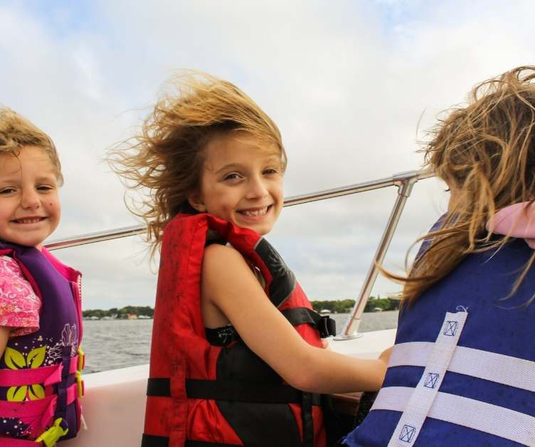3 girls on boat wearing life vest